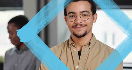 1. A man wearing glasses stands in front of a blue square, focusing on the object.