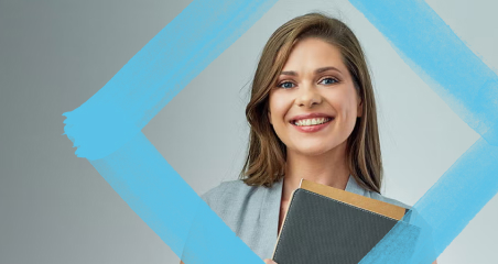 1. A woman smiles while holding a book, standing in front of a blue frame.