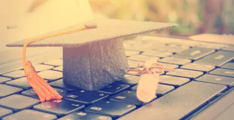 A focused MBA student studying at a desk with textbooks and laptop resources.