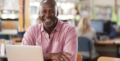 Expert financial planner reviewing comprehensive wealth management solutions with a smile in an office.