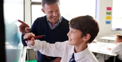 An experienced teacher providing one-on-one academic guidance to a young, focused student.