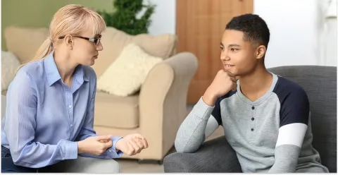 A child and adolescent mental health professional speaks with a teenager